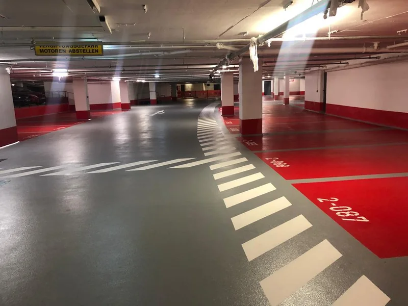 Rot und grau gestaltete Parkfläche mit Markierungen
